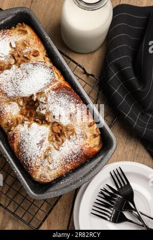 Delicious yeast dough cake in baking pan and milk on wooden table, flat lay Stock Photo