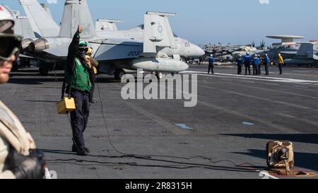 Aviation Boatswain's Mate (Equipment) 3rd Class Darion Thornton (left), from Charleston, South Carolina, assigned to the worldÕs largest aircraft carrier USS Gerald R. FordÕs (CVN 78) air department, operates the jet blast deflectors on the flight deck, June 9, 2023. Gerald R. Ford is the U.S. NavyÕs newest and most advanced aircraft carrier, representing a generational leap in the U.S. NavyÕs capacity to project power on a global scale. The Gerald R. Ford Carrier Strike Group is on a scheduled deployment in the U.S. Naval Forces Europe area of operations, employed by U.S. Sixth Fleet to defen Stock Photo