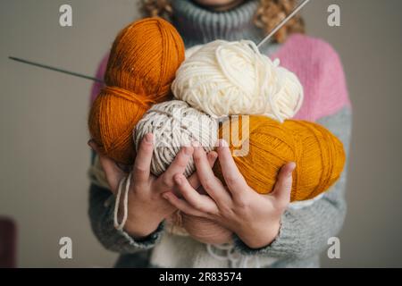 Woman holding in her hands skeins of knitting yarn. Yarn for knitting toys, children's and adult clothes, interior items. Handmade hobby. Stock Photo