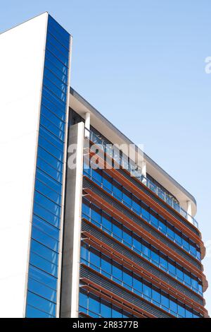 A high-rise building comprising a mix of design elements including glass set into angled and curved fames Stock Photo