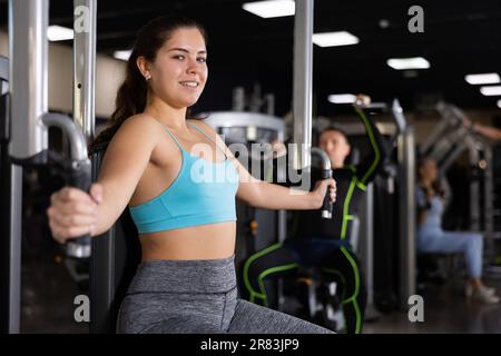 Young woman doing exercise on a chest machine fly in the gym. Women wear  sportswear flexing arm muscles on chest machine fly in gym 25889107 Stock  Photo at Vecteezy