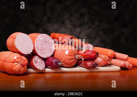 A variety of processed cold meat products, on a wooden cutting board Stock Photo