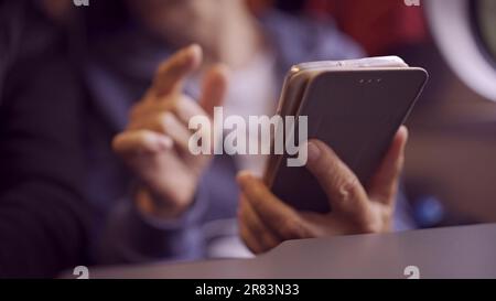 Close-up of the hands of a elderly lady sitting in a train carriageriage and using a smartphone Stock Photo