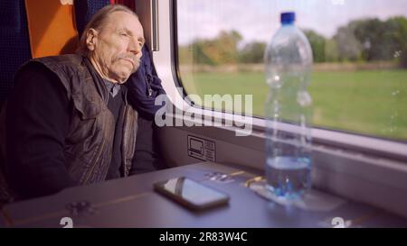 Warsaw, Poland. 11th June, 2023. Close up of senior with glasses travels in a train and looks at out the window (Credit Image: © Andrey Nekrasov/ZUMA Press Wire) EDITORIAL USAGE ONLY! Not for Commercial USAGE! Stock Photo