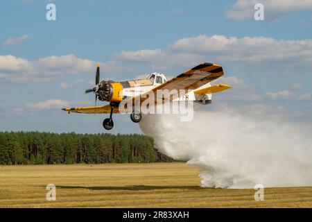 PZL M18 Dromader firefighting aircraft during discharge of extinguishing agent Stock Photo