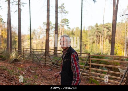 Portrait of an elderly man in a plaid shirt in the autumn forest Stock Photo