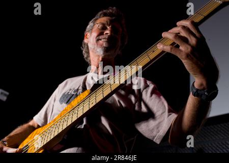 An older man plays bass guitar on stage at a jazz club in San Diego, California. Stock Photo