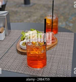 Two glasses of Aperol Spritz and some snacks on the table, Bellagio, Italy Stock Photo