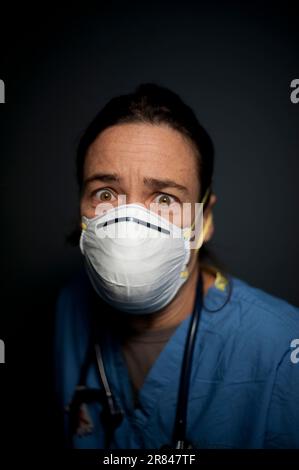 Studio portrait of 42 year old caucasian female registered nurse wearing a N95 mask. Stock Photo