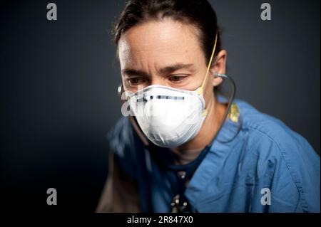 Studio portrait of 42 year old caucasian female registered nurse wearing a N95 mask. Stock Photo
