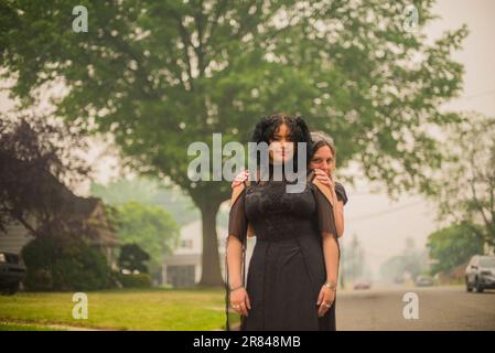 Mother hugs daughter who is Dressed for the senior Prom Stock Photo