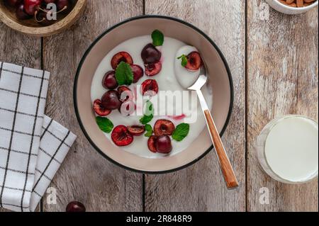yogurt with cherries in a plate, milk in a bottle and glass on a Stock Photo
