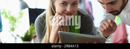 Professional tailors work on project using tablet in fashion design studio Stock Photo