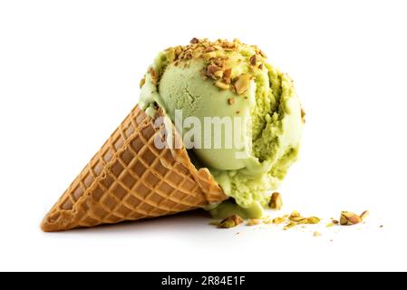 Cone of pistachio ice cream sprinkled with nuts on a white background. Stock Photo