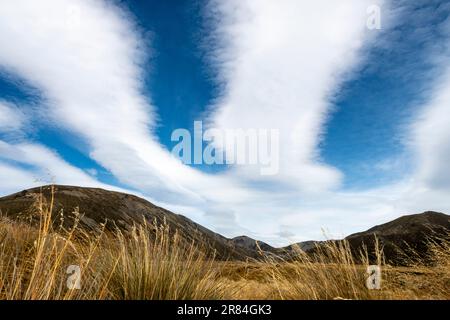 Long clouds over mountains and tussock, Lake Tennyson, near Hanmer Springs, Canterbury,South Island, New Zealand Stock Photo