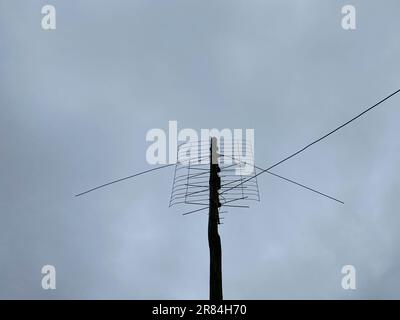 Old outdoor antenna for receiving a television signal against a bright blue sky. Stock Photo
