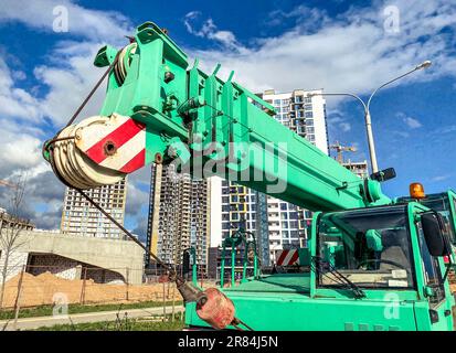 The boom-type crane moves without a load, without requiring special tracks. truck crane at the construction site of a new microdistrict, heavy automot Stock Photo