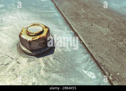 metal texture. a large screw is screwed on a gray sheet of metal, fastening two sheets together. metal and bolt rusted. 3d background, background. Stock Photo