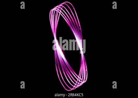 A pink swirl on a black backdrop Stock Photo