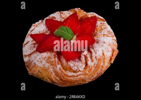 Danish pastry adorned with fresh strawberries and creamy custard filling on black isolated setting Stock Photo