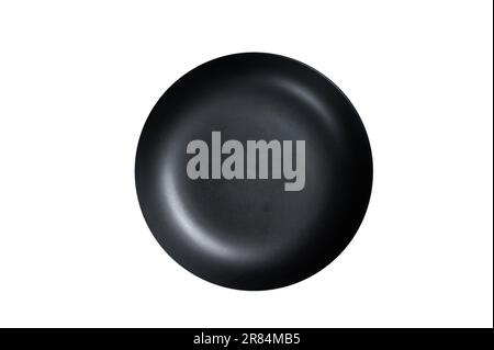 Empty black craft plate on table. Table setting. Isolated on white background. Stock Photo