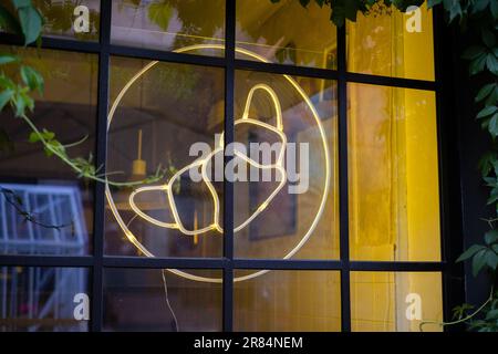 Croissant neon light sign hanging on café window. Stock Photo