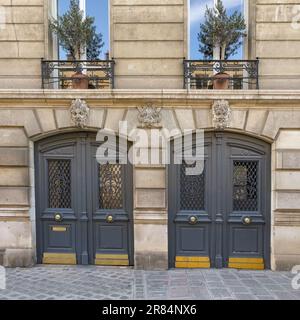 Paris, an old wooden door, with a head carved on the lintel, typical building in the Marais Stock Photo