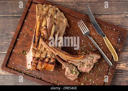 Grilled lamb chops on a wooden serving plate Stock Photo
