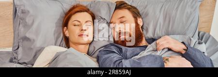 quiet house, parents alone at home, redhead husband and wife sleeping in cozy bedroom, bearded man and carefree woman relaxing on weekends, day off, t Stock Photo