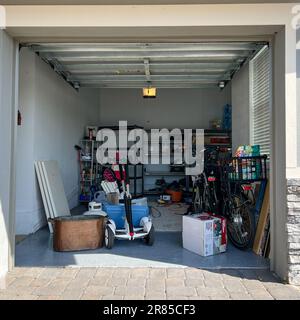 Orlando, FL USA - March 3, 2022: An unorganized garage filled with a lot of stuff in a neighborhood. Stock Photo
