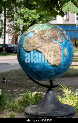 photo metallic globe sculpture in the street background is blurred Stock Photo