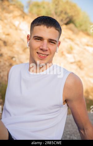Portrait of an adolescent boy outdoors listening to music with his wireless earphones Stock Photo