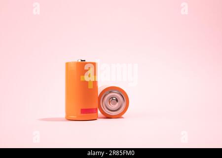 Orange battery on pink background, energy concept Stock Photo
