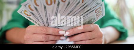 Business office desk woman counting money on hands analyzing income charts and graphs Stock Photo