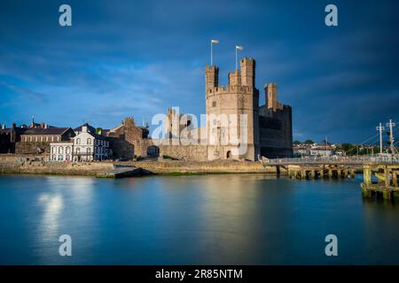 Majestic Caernarfon Castle: Sunlit beauty in North Wales captured with long exposure Stock Photo