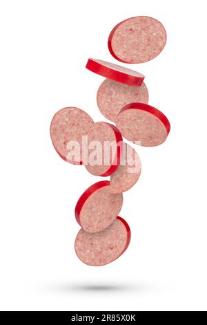 Flying sausage. Slices of salami sausage on a white isolated background. Slices of sausage scatter in different directions and fall casting a shadow Stock Photo