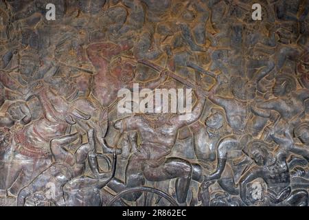 The rich heritage of Khmer civilization, shown through the detailed carvings of Hindu mythology battle scenes on the ancient temple stone walls. Stock Photo