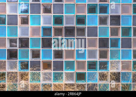 Colored glass tiles background as exterior wall on a facade. Building construction with glass blocks for contemporary wall with white, grey, brown and Stock Photo