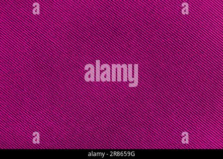 Pink, purple carbon fiber background. Texture of red fabric for tailoring. Textile Stock Photo