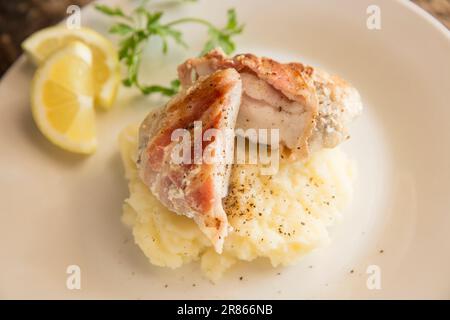 The home cooked cheek from an Anglerfish, Lophius piscatorius, that has been wrapped in bacon and fried. Served on mash. Anglerfish are sometimes call Stock Photo