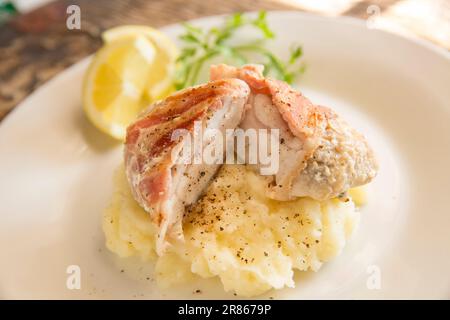 The home cooked cheek from an Anglerfish, Lophius piscatorius, that has been wrapped in bacon and fried. Served on mash. Anglerfish are sometimes call Stock Photo