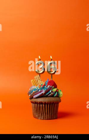 birthday cake with number 36 - cupcake on orange background with birthday candles Stock Photo