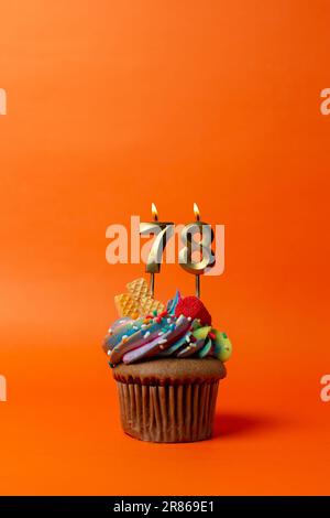 birthday cake with number 78 - cupcake on orange background with birthday candles Stock Photo