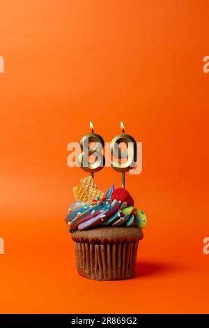 birthday cake with number 89 - cupcake on orange background with birthday candles Stock Photo