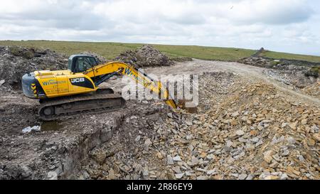 360 Excavator in a quarry for stone to be used in dry stone walling on local farms. Cumbria, UK. Stock Photo