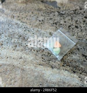Tesla ecstasy pills in orange, green, and blue color shaped like a shield with the Tesla logo; 240 milligrams of recreational MDMA or Molly; drugs Stock Photo