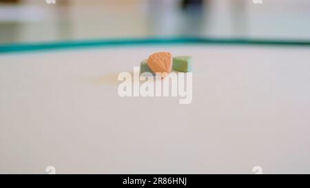 Tesla ecstasy pills in orange, green, and blue color shaped like a shield with the Tesla logo; 240 milligrams of recreational MDMA or Molly; drugs Stock Photo