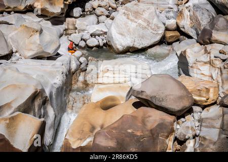 A holy man meditates on the banks of the source of the Ganges River, Gangotri, Uttarakhand, India Stock Photo