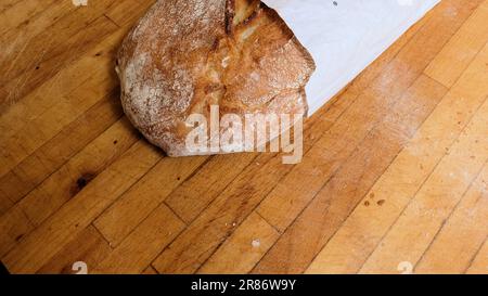 A ciabatta loaf of bread on a wooden cutting board; Italian bread. Stock Photo