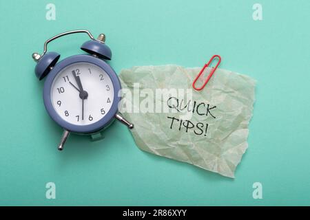 Quick Tips text on a blue background with alarm clock Stock Photo